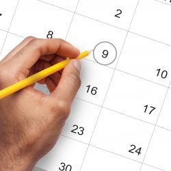 Male hand marking circle on calendar as a reminder about important day